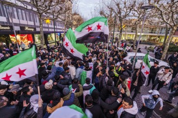 Gli esuli siriani celebrano la caduta del regime di Assad a Stoccarda, in Germania, sventolando la bandiera nazionale siriana foto Andreas Arnold/Ap