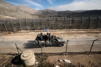 Un veicolo israeliano si muove lungo una strada verso il lato siriano del confine tra Israele e Siria nelle alture del Golan annesse da Israele foto Atef Safadi/Ansa